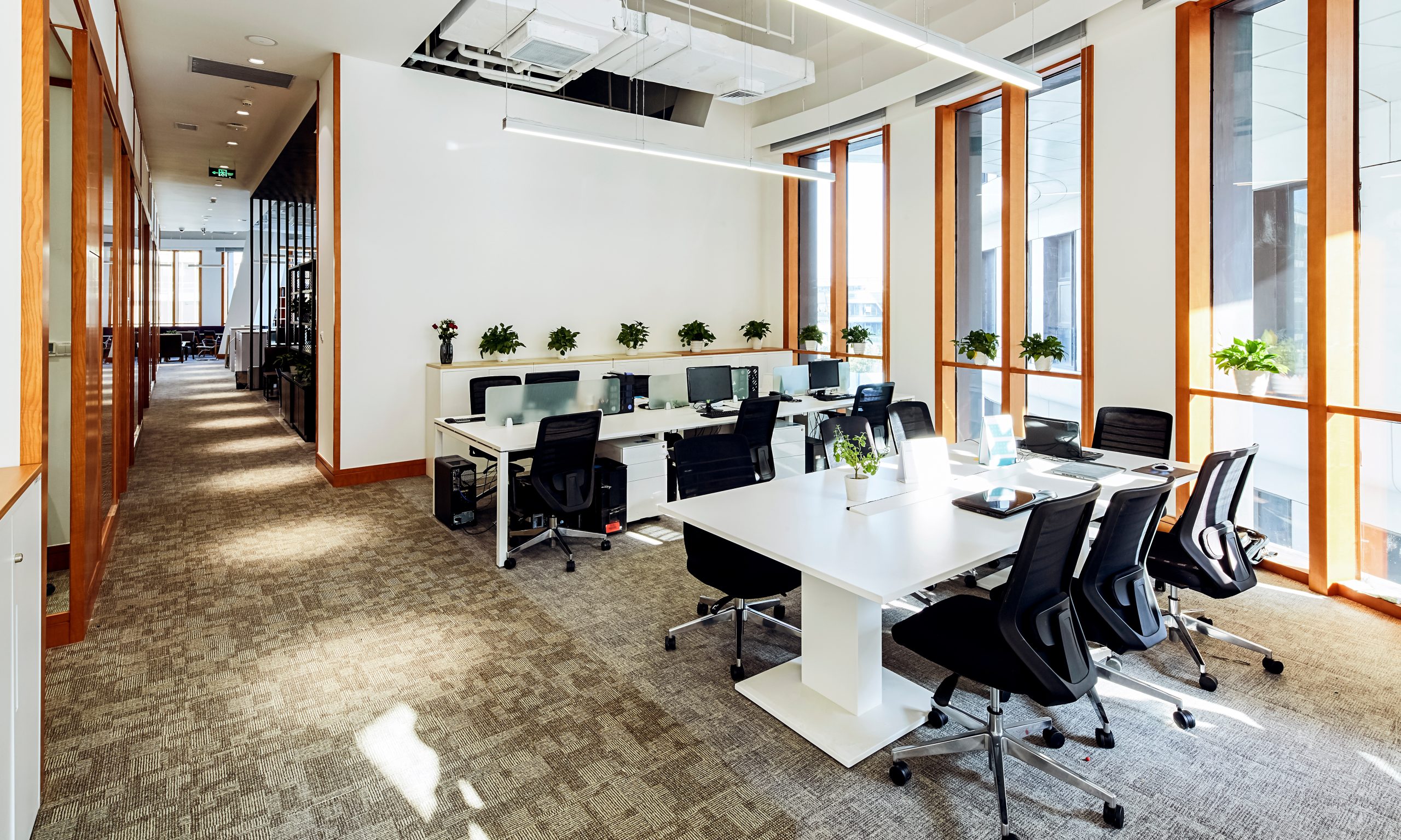 The interior of an office space with tables, computers, and chairs