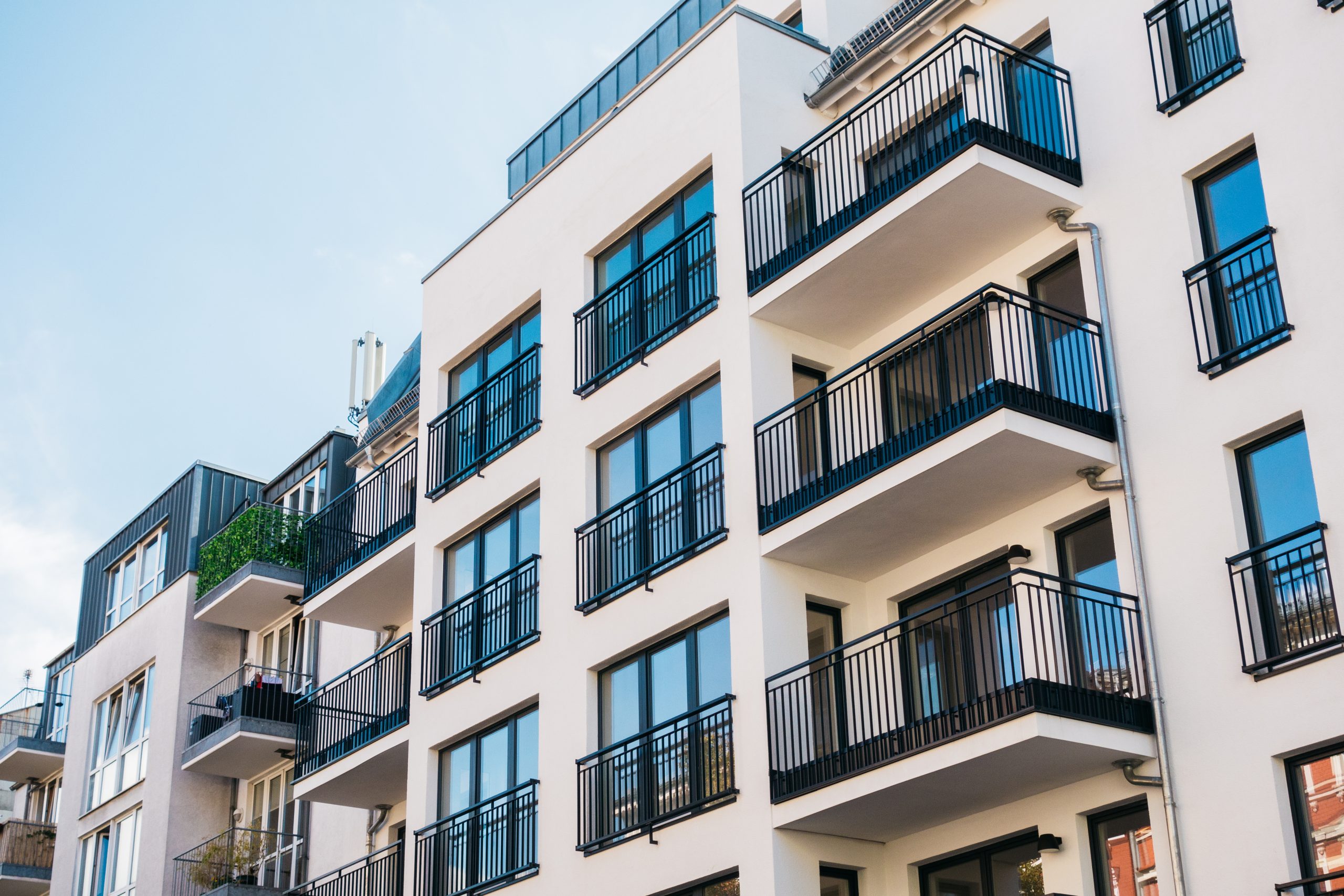 The outside of an apartment building with balconies on each apartment.